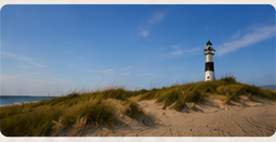Leuchtturm auf einer Düne unter blauem Himmel